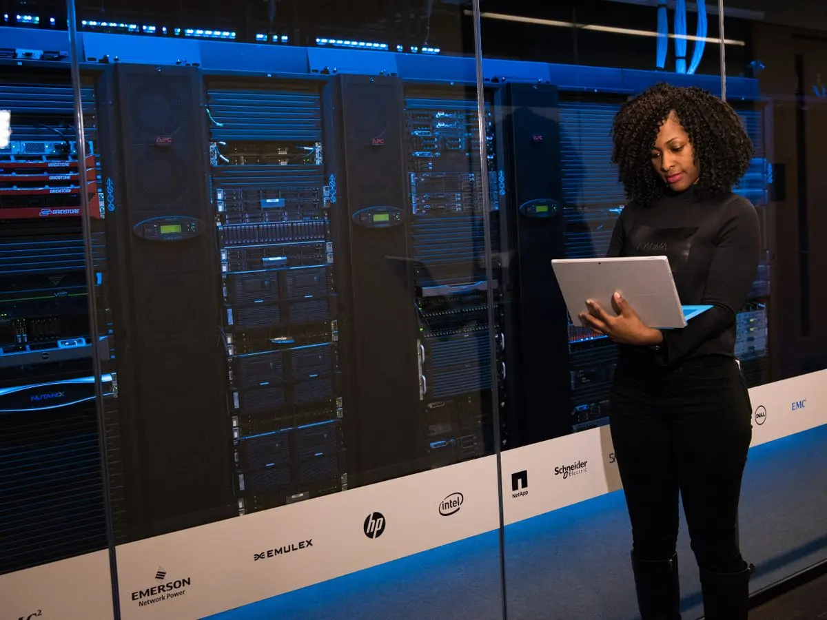 Engineer reviewing equipment beside rows of server racks