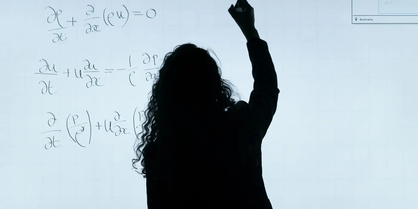 A person writing equations on a whiteboard